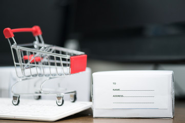 Red trolley on laptop keyboard.A cart and box product for send to customer .Electronic commerce...