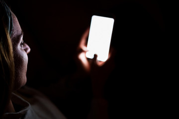 Naklejka premium young woman at home using mobile phone. Night time