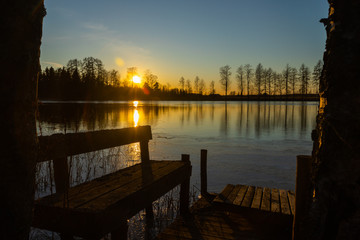 Beautiful sunset and bench on river Kymijoki in February, Finland.