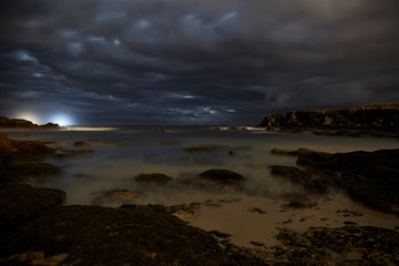 Obraz premium Landscape of rocks and cliffs in nature in the town of Noja made at night at low tide, Cantabria, Spain.