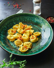 tortellini, pasta with filling (ravioli or dumplings)
second course
Menu concept. food background. top view copy space for text