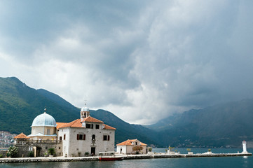 Fototapeta na wymiar Thunderclouds over Our Lady of the Rock Island near town Perast, a very popular tourist destination, Kotor Bay, Montenegro