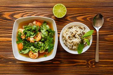 Thai soup with shrimp and seafood and a bowl of rice