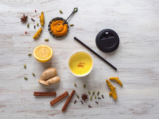Golden milk in a paper cup with turmeric, cinnamon,ginger, lemon and pepper. Prevention of antiviral infections