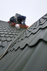 Working with roofing material, metal roof, hand tools screwdriver.