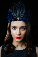 Portrait of gorgeous brunette woman in luxurious headdress posing against dark studio background. Beautiful girl with a healthy clean skin and with red lips.