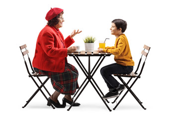 Grandmother and grandson sitting in a cafe and talking