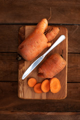 Trendy ugly organic carrot from home garden bed on barn wood table, Australian grown. Color-toning effect applied.