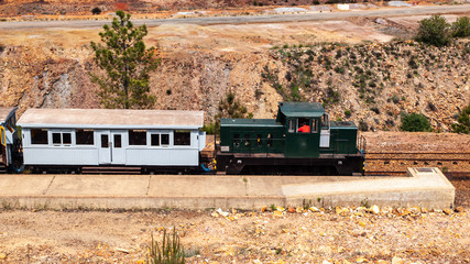 Locomotora verde con un vagón de pasajeros blanco en la estación del tren turístico de Riotinto...