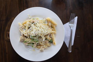 penne pasta with vegetables and glass of wine top view