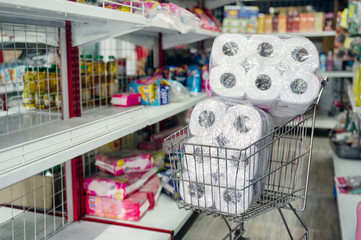 Customer hoarding tissue, toilet paper on shopping cart in retailer
