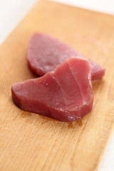 Raw tuna steak on wooden cutting board