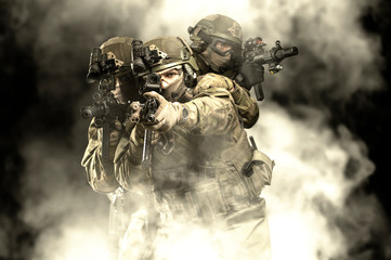 American soldiers in combat ammunition with weapons in the hands of equipped laser sights are in...