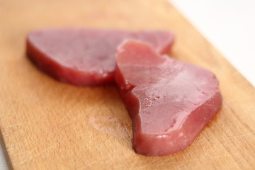 Raw tuna steak on wooden cutting board