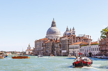 Water channels of Venice city. Facades of residential buildings overlooking the Grand Canal and Basilica di Santa Maria della Salute in Venice, Italy.