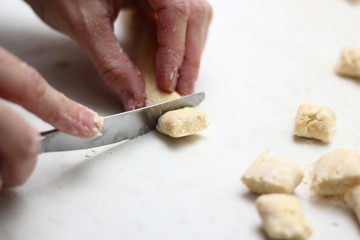 Gnocchi being prepared. Cutting dough. Dough dumplings with cheese.
