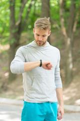 Watch ideal for active lifestyle. Athletic man check pulse by watch. Handsome athlete use smart...