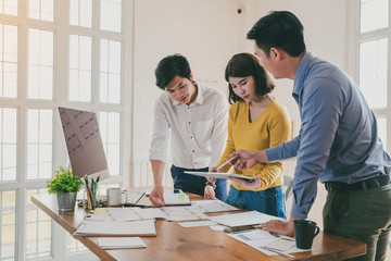 Group of young asian creative people. Mobile application designers and website designers brainstorm and planning project work together.