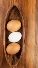 Easter holidays concept. Organic eggs in wooden bowl on wood background with copyspace. Copyspace, place for text and wording.