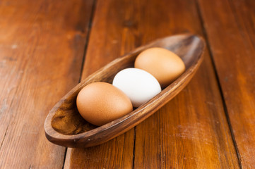 Easter holidays concept. Organic eggs in wooden bowl on wood background with copyspace. Copyspace, place for text and wording.