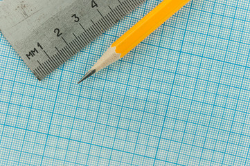 drawing compass, pencil, and ruler on graph paper background