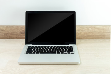 Laptop with black screen isolated on a wooden desk