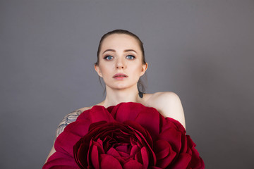  beautiful girl with healthy skin relaxes after a Spa treatment with a red flower