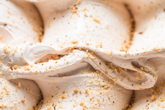 Walnut flavour gelato - full frame detail. Close up of a white surface texture of walnut Ice cream covered with little brown pieces of milled wallnuts