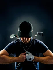 Poster Close-up of a golf player with golf irons crossed on his chest, isolated on black background, vertical image © trattieritratti