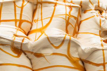 Caramel flavour gelato - full frame detail. Close up of a white surface texture of Caramel Ice cream covered with brown stripes
