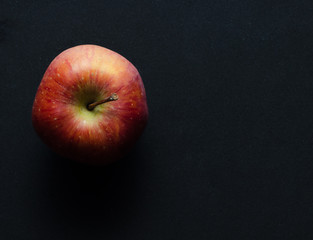 red apple on a black background, close-up top
