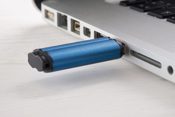 Closeup of USB memory stick and laptop computer.