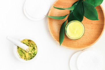 Healthy skincare body treatment, summer skin nourishment with ripe avocado. Mixing green avocado fruit in mortar, jar with skincare vegan cosmetic mask. 
Home spa beauty routine, ingredients top view 