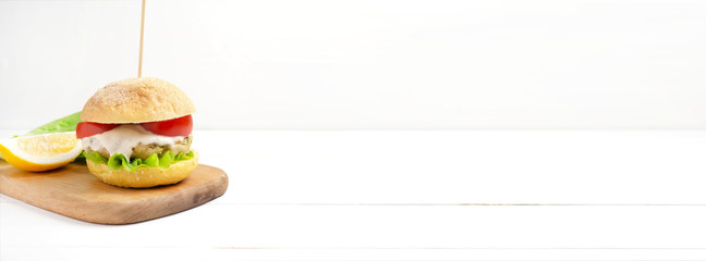 Vegetarian burgers with ready- made cutlets and cashew nut sauce , tomato slice and salad on a white wooden background. Vegan, vegetarian, healthy food, superfood.