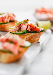 Toasts with fresh cucumber and smoked salmon served with lime shavings.