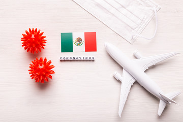 Plane model and face mask and flag Mexico. Coronavirus pandemic. Flight ban and closed borders for tourists and travelers with coronavirus covid-19 from Europe and Asia.