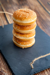 buns with sesame for burgers. black stone tray.