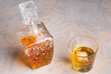 Whisky glass decanter hall-full with whisky liquor and an empty glass of whiskey on table top view