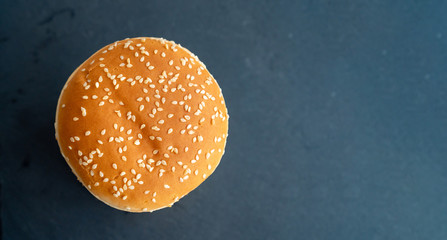 bun with sesame for burgers. black stone tray.