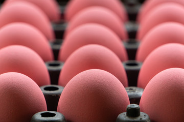 The pink century eggs are lined up in a black egg tray, the focus image on the front row.