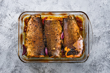 Top view of pan with red salmon baked in oven with spice