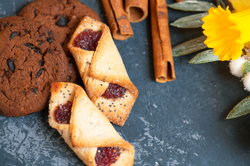Cookies with chocolate, cinnamon sticks, on the  stone background with spring flowers.