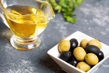 Fresh natural black and green olives, olive oil on the stone background.