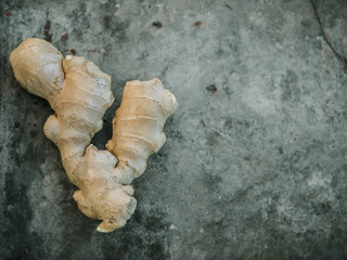 Whole Ginger root on dark grey background, top view.