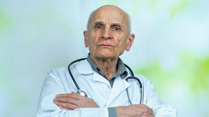 portrait of aged wise pensioner doctor in white uniform