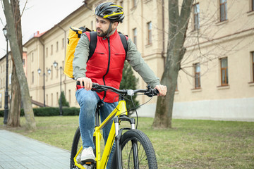 Fototapeta na wymiar Courier with thermo bag riding bicycle outdoors. Food delivery service
