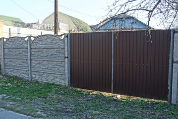 Obraz premium big brown metal gate and fence on a rural street