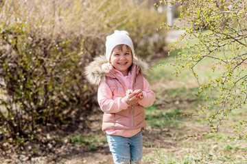 Little girl walks in nature in the spring park