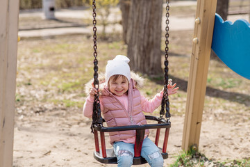 Little girl walks on the playground in the street
