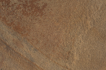 Natural stone of dark brown color with a chipped uneven texture background